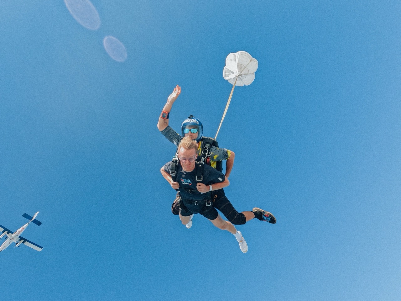 Nathan in freefall on a tandem skydive under a clear blue sky